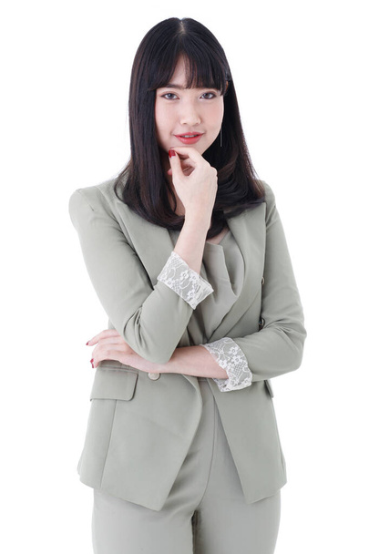 Pystysuora muotokuva kuva söpö hymyilevä aasialainen nainen tyylikäs suora kampauksen harmaita vaatteita seisoo ja katsot kameraa ristissä kädet ja käsi leuka poseeraa studiossa - Valokuva, kuva