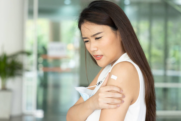 Sağlıksız Asyalı kadın kas ağrısı, aşı konsepti, aşı, aşı, aşının yan etkileri, istenmeyen yan etkilerle koronavirüs antikor tepkisi aşısı oluyor. - Fotoğraf, Görsel