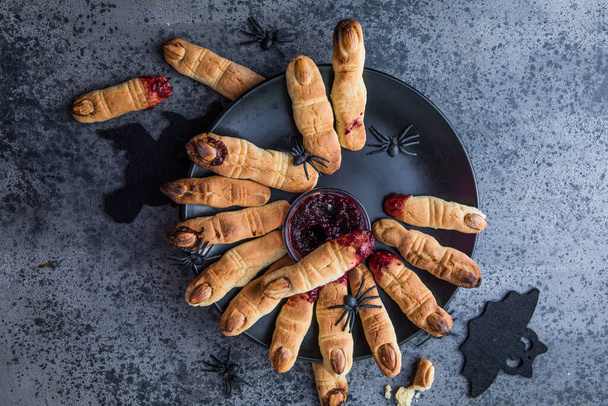 Кровавые пальцы для празднования Хэллоуина, печенье "Ведьмины пальцы". Темный фон, еда для Хэллоуина - Фото, изображение