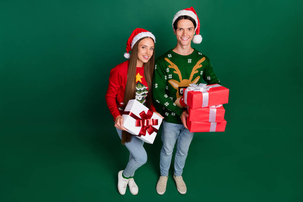 Top above view photo of positive couple prepare gift exchange wear hat ugly pullover isolated green color background - Φωτογραφία, εικόνα