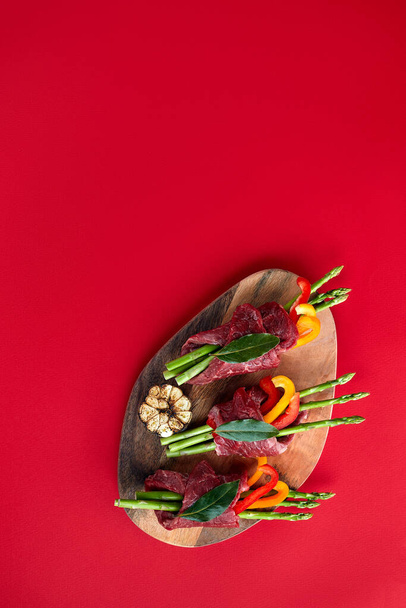 Rolamentos de carne crua e guarnições de vegetais frescos prontos para cozinhar em um fundo branco - Foto, Imagem