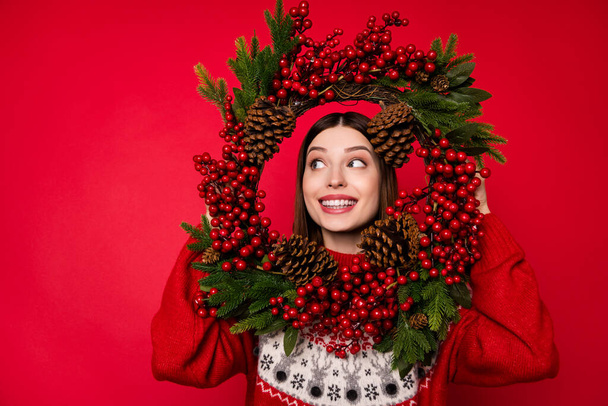 Photo of pretty funny woman dressed print pullover looking inside new year decoration empty space isolated red color background - 写真・画像