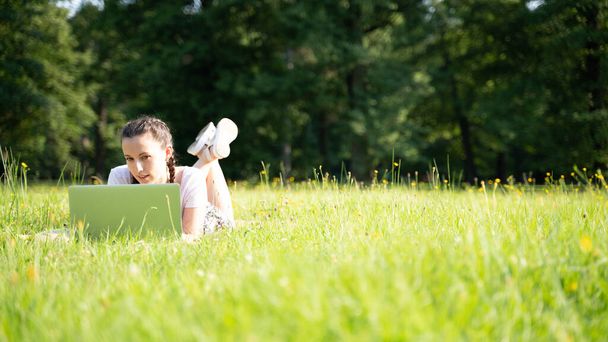 夏の公園でラップトップ、コンピュータタブレットと学生の女性のオンラインビジネス。女の子の人は自然の屋外で動作します。テクノロジー以外の人々。電子ガジェット距離学習の概念 - 写真・画像
