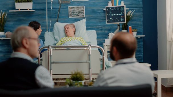Senior patient with sickness talking to nurse about treatment - Valokuva, kuva