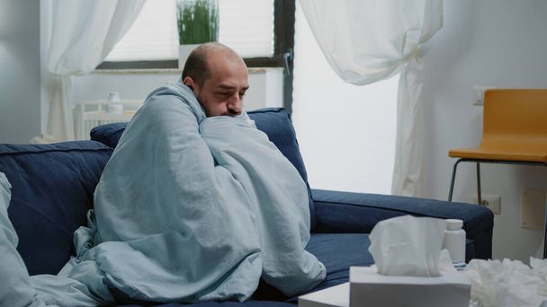 Person with flu feeling cold and shivering wrapped in blanket - Photo, Image