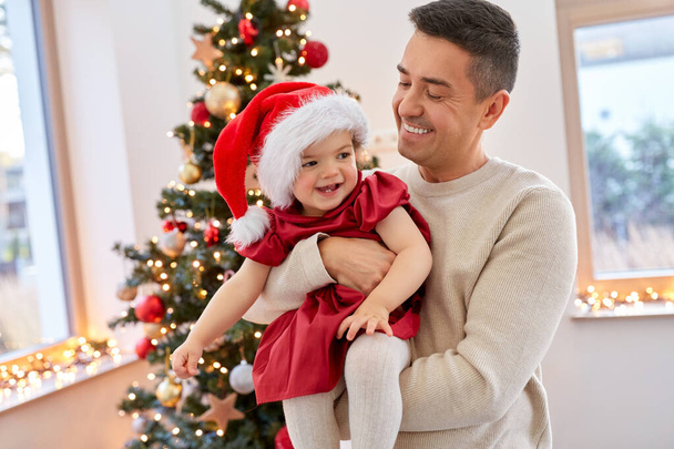 happy father and baby girl over christmas tree - Фото, зображення