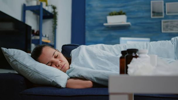 Женщина с болезнью спит в одеяле на диване - Фото, изображение
