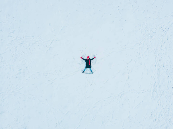 happy woman making snow angel view directly above - Fotoğraf, Görsel