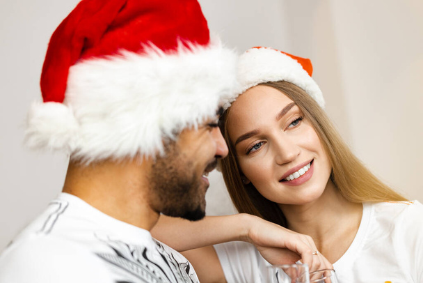 Cheerful attractive happy couple in Santa hats - Foto, Bild