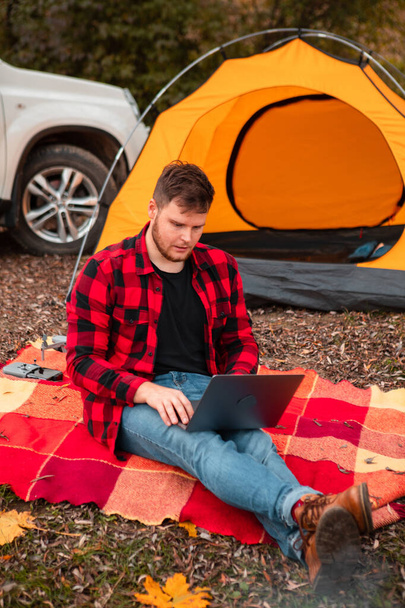 man working on laptop at camping site autumn fall season. freelance concept - Photo, Image