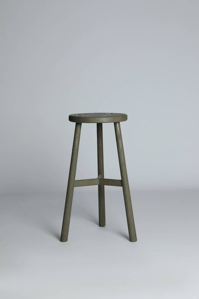 Stylish wooden stool on light grey background. Interior element - Φωτογραφία, εικόνα