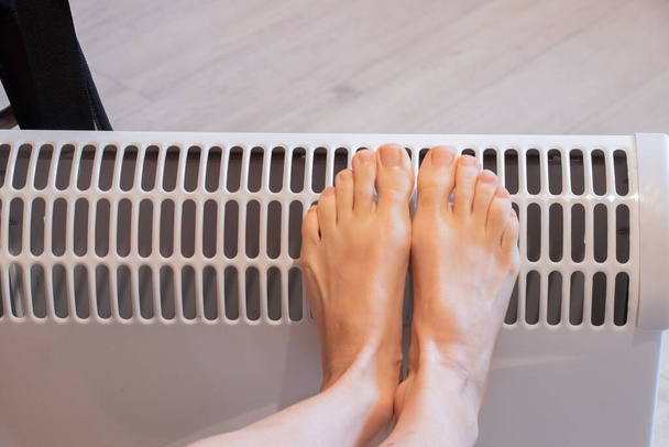 naisten jalat akku kotona, lämmityskausi, lämpimät jalat sähköakulla, jalat - Valokuva, kuva
