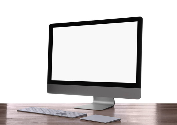 Modern computer with blank monitor screen and peripherals on wooden table against white background - Photo, image