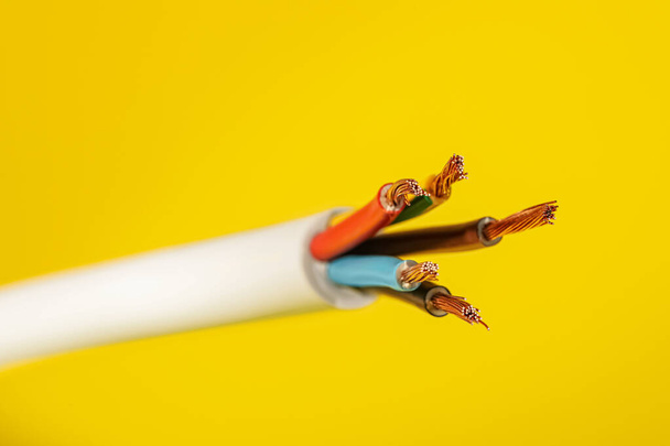 Electrical wires on yellow background, closeup view - Фото, изображение