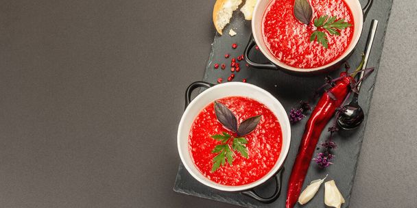 Острый осенний томатный суп. Здоровая горячая еда, чеснок, чили, базилик. Черный камень бетонный фон, формат баннера - Фото, изображение