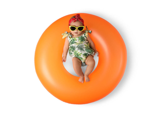 Cute little baby in sunglasses with inflatable ring on white background, top view - Foto, afbeelding