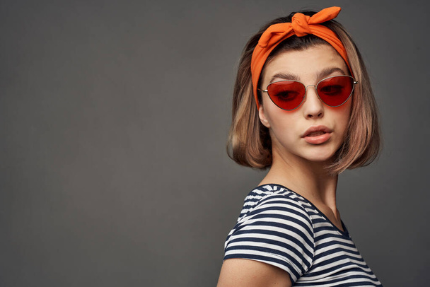 vrouw dragen zonnebril met oranje verband op hoofd geïsoleerde achtergrond mode - Foto, afbeelding