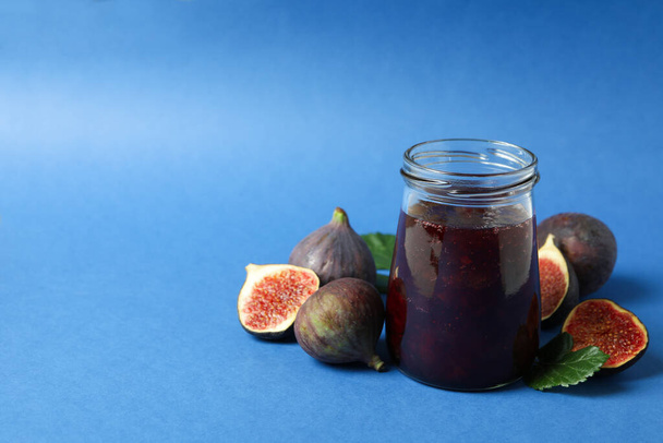 Sklenice s fíkovým džemem a ingredience na modrém pozadí - Fotografie, Obrázek