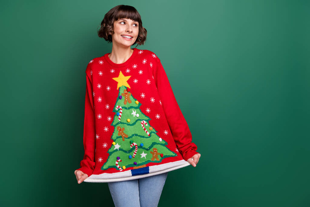 Photo of funny girlish young woman dressed red pullover smiling looking empty space isolated green color background - Φωτογραφία, εικόνα