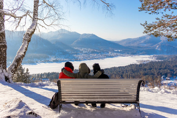 trzech przyjaciół zrelaksować się na ławce i podziwiać krajobraz zimowy - Zdjęcie, obraz