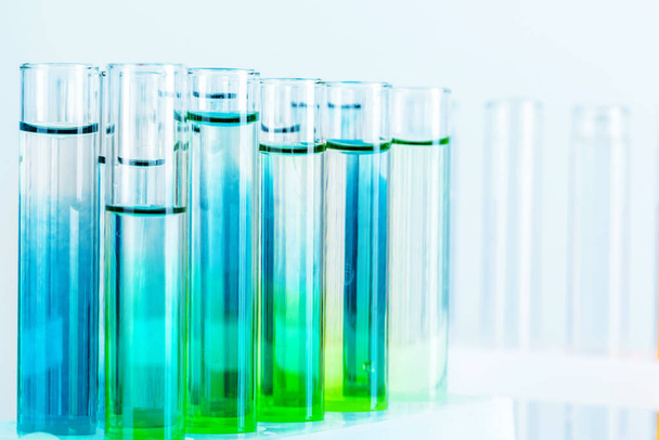 Different laboratory glassware with colored liquids close up - Foto, imagen