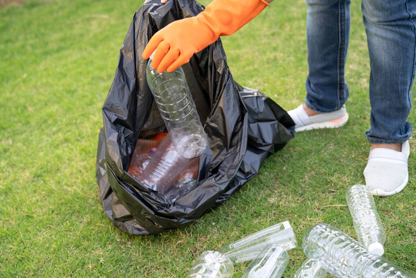 Mujer asiática voluntaria llevar botellas de plástico de agua en la basura bolsa de basura basura en el parque, reciclar residuos ambiente ecología concepto. - Foto, imagen