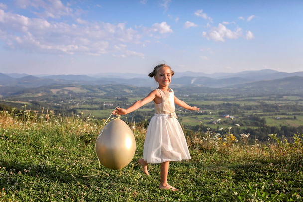 Festa após encerramento. Menina dançando sozinha com balões de ar no topo das montanhas, novo normal - Foto, Imagem