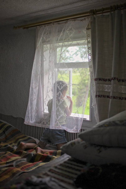 Roztomilé dítě otevírá okno na čerstvý vzduch v časném ránu ve vesnickém domově - Fotografie, Obrázek