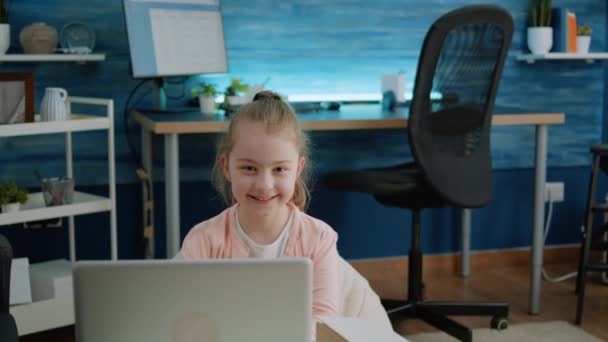 Muotokuva nuori tyttö hymyilee ja tilalla kannettava tietokone kotona - Materiaali, video