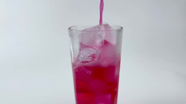 Verser des boissons gazeuses, soda rouge dans le verre isolé o fond blanc  - Séquence, vidéo