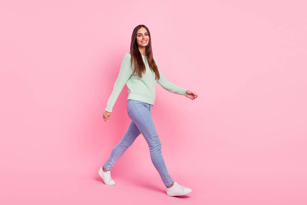 Foto lateral de perfil de tamaño completo de la joven mujer alegre sonrisa positiva feliz ir caminando reunión aislado sobre fondo de color rosa - Foto, imagen
