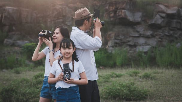 Vintage family of  photographers are happily taking pictures with the film camera - Фото, изображение