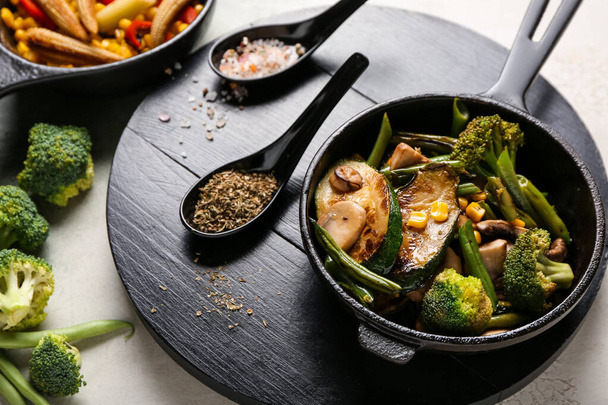 Сковородка с различными овощами и специями на светлом фоне - Фото, изображение