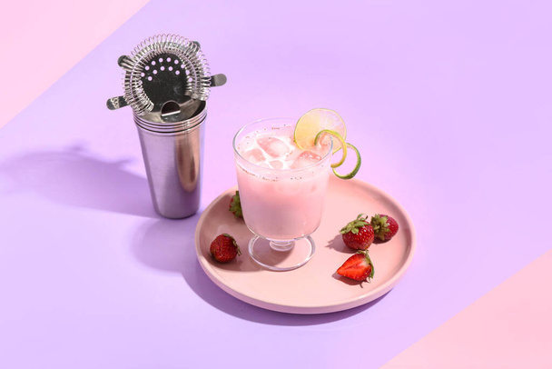 Glass of strawberry Pina Colada cocktail, shaker and strainer on color background - Photo, Image