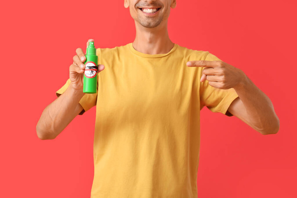 Young man with mosquito repellent on color background - Photo, Image
