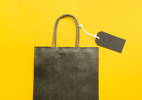 Shopping bag and tag on color background. Black Friday sale - Photo, image
