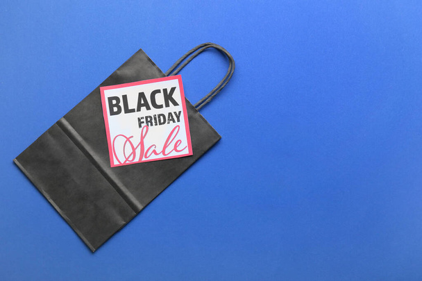 Shopping bag and card with text BLACK FRIDAY SALE on color background - Valokuva, kuva