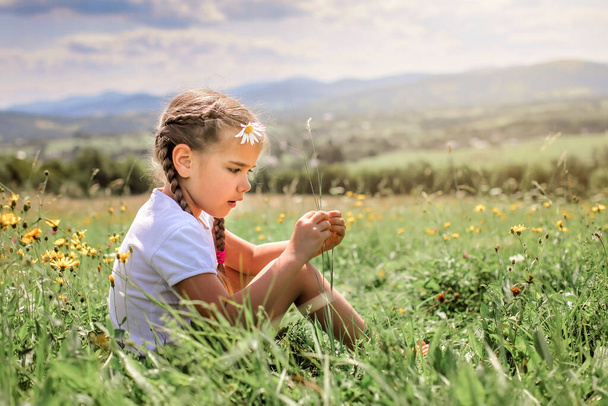 Atrakcyjna dziewczyna relaksująca się rano na zielonej trawie na szczycie gór - Zdjęcie, obraz