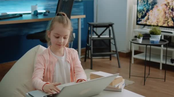 Malé dítě pomocí klávesnice na notebooku pro domácí úkoly a on-line kurzy - Záběry, video