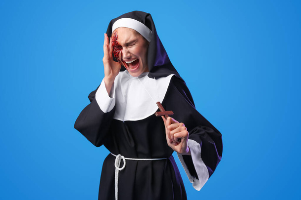 Sikoltozó nő öltözött Halloween apáca színes háttér - Fotó, kép