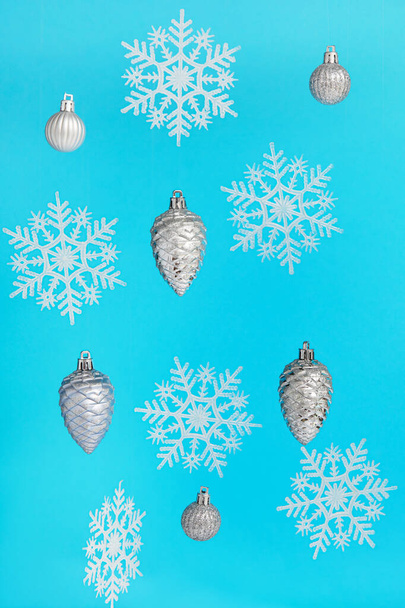 青い背景に雪の結晶とクリスマスボール - 写真・画像