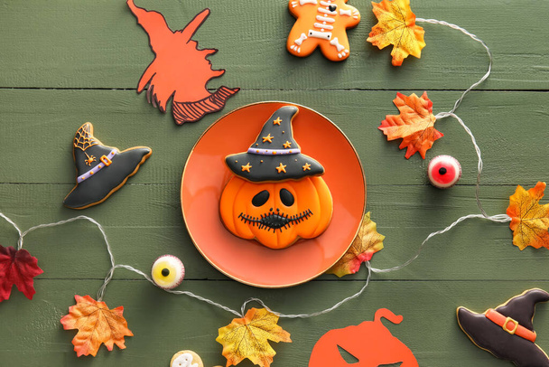 Tasty cookies for Halloween celebration with decor on color wooden background - Фото, изображение