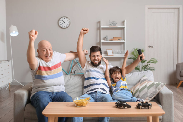 Man, his little son and father watching TV at home - Photo, image