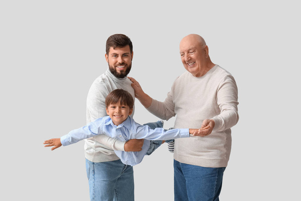 Onnellinen mies, hänen pieni poikansa ja isänsä valoisalla taustalla - Valokuva, kuva