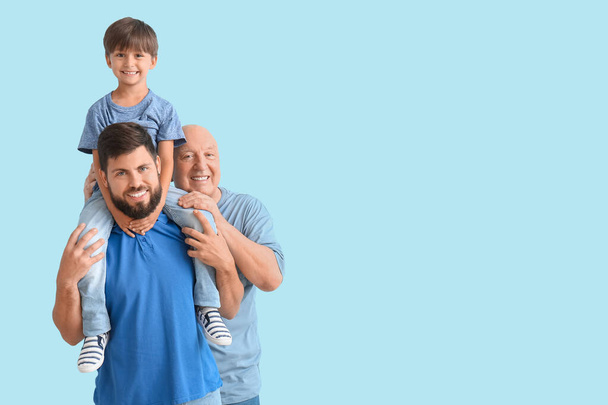 Szczęśliwy człowiek, jego mały syn i ojciec na tle koloru - Zdjęcie, obraz