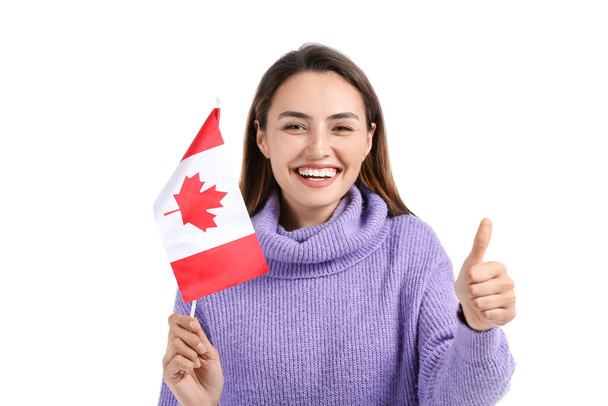 Beautiful young woman with flag of Canada showing thumb-up on white background - Foto, imagen