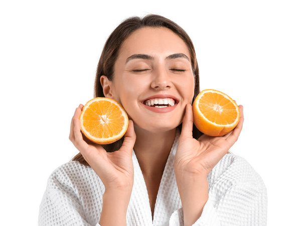 Schöne junge Frau mit frischem Orange auf weißem Hintergrund - Foto, Bild