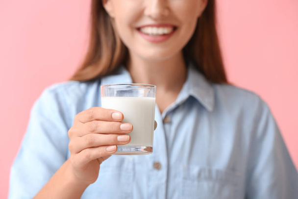Junge Frau mit Glas frischer Milch auf farbigem Hintergrund, Nahaufnahme - Foto, Bild