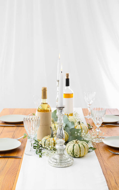 Hermosa mesa de madera servida, vela encendida en el candelero y decoración de otoño en la habitación - Foto, imagen