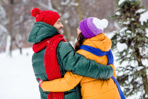 Photo of adorable sweet girlfriend boyfriend dressed vests smiling hugging looking each other enjoying walking snow outdoors forest - 写真・画像